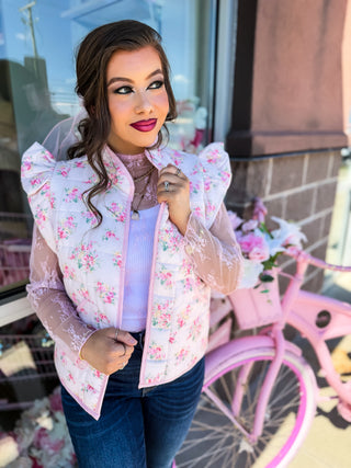 Soft quilted vest with ruffle detail and florals and bow design. Pockets. 