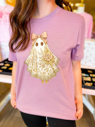
Coquette ghost tee with lace floral details and bow on lavender shirt—girly feminine Halloween graphic tee for soft spooky style.