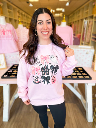 
A girly Halloween sweatshirt with bows, haunted house, ghost, pumpkin, and witch hat—perfect for fall outings. 
