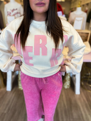 Person wearing a white sweatshirt with pink text and pink pants in a store setting