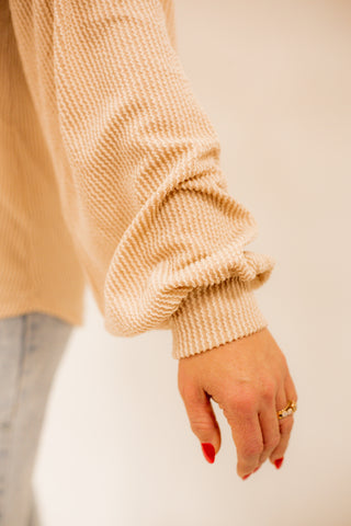 Textured long sleeve top with v-neck line and bell sleeve details. 