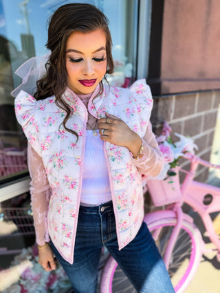 Soft quilted vest with ruffle detail and florals and bow design. Pockets. 