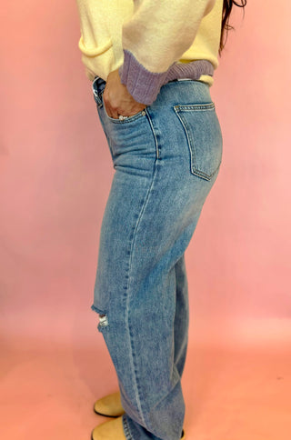 Kan Can brand light wash denim with slight distressing, straight leg fit, and cross over waist line. 