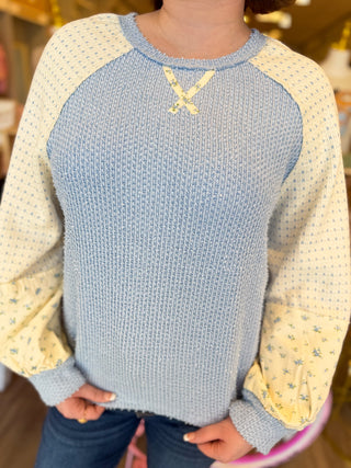Women’s boutique fall sweaters in pink and blue with floral sleeves, modeled at Bailey Kate Boutique. Cozy pastel outfits for women — soft waffle-knit color block tops styled with denim for a chic, feminine fall look.