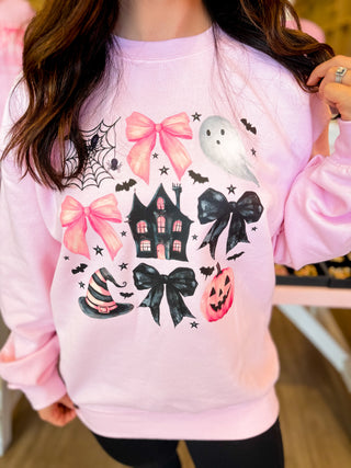 
A girly Halloween sweatshirt with bows, haunted house, ghost, pumpkin, and witch hat—perfect for fall outings. 
