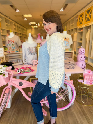 Women’s boutique fall sweaters in pink and blue with floral sleeves, modeled at Bailey Kate Boutique. Cozy pastel outfits for women — soft waffle-knit color block tops styled with denim for a chic, feminine fall look.