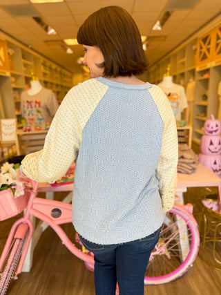 Women’s boutique fall sweaters in pink and blue with floral sleeves, modeled at Bailey Kate Boutique. Cozy pastel outfits for women — soft waffle-knit color block tops styled with denim for a chic, feminine fall look.